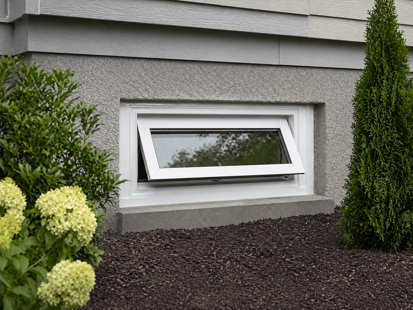 Basement or hopper window on a clean foundation wall